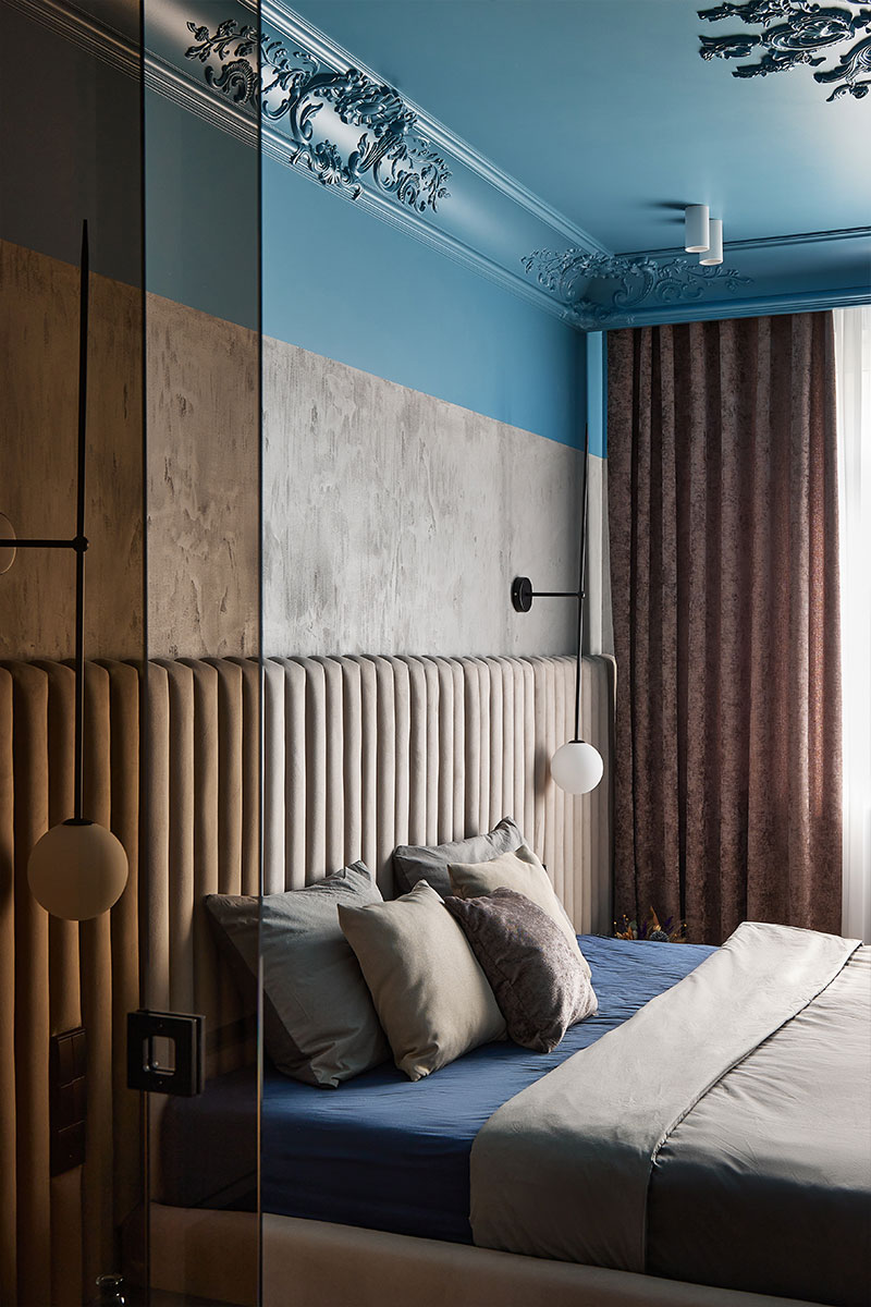 Спальня с бетонными стенами, голубым потолком и декоративной лепниной