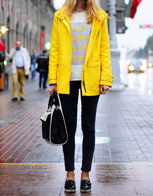 Девушка в узких штанах и желтом дождевике.