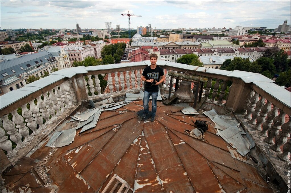 Фотограф на башне с часами на проспекте Независимости в Минске. 