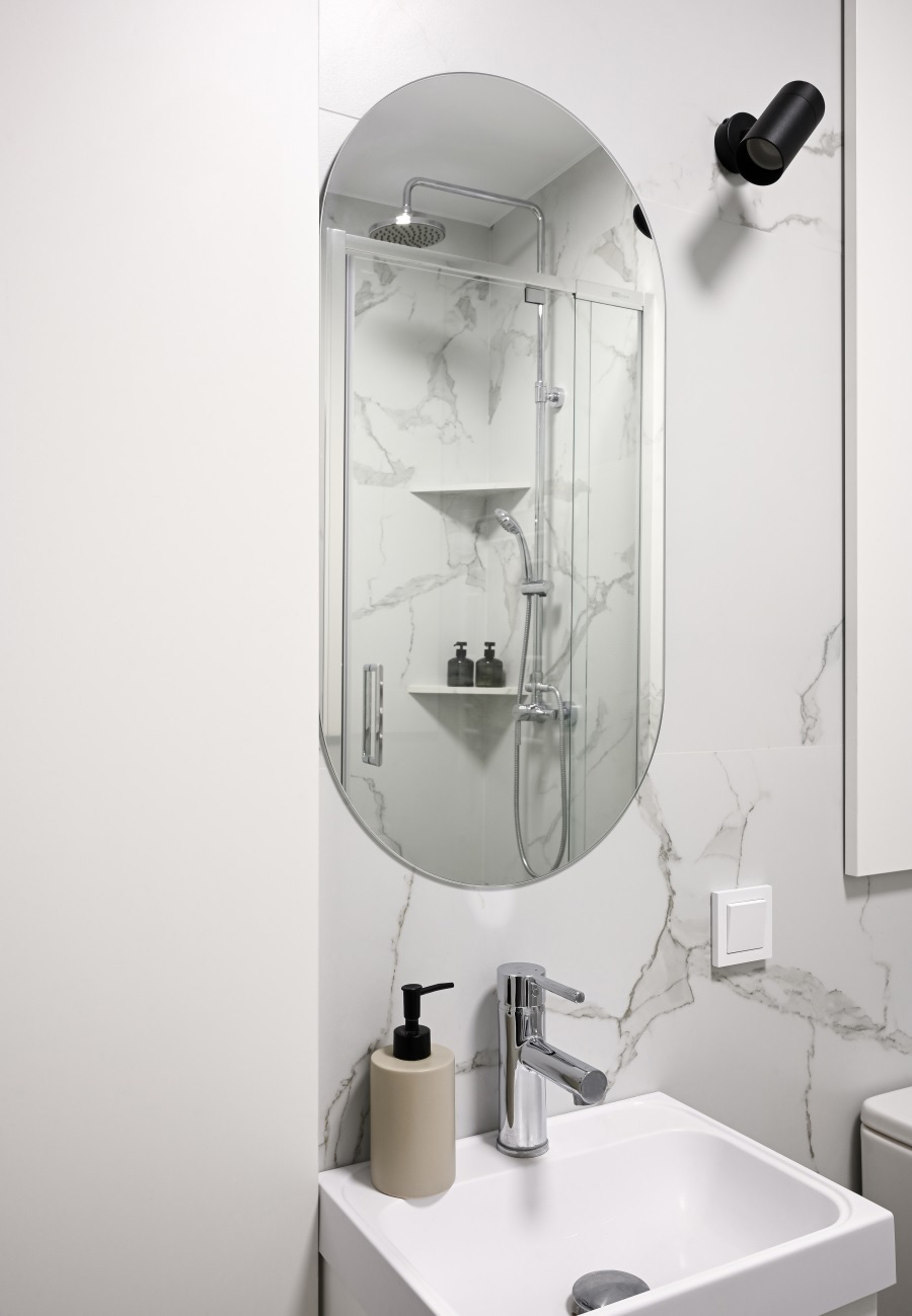 Овальное зеркало и умывальник для ванной.