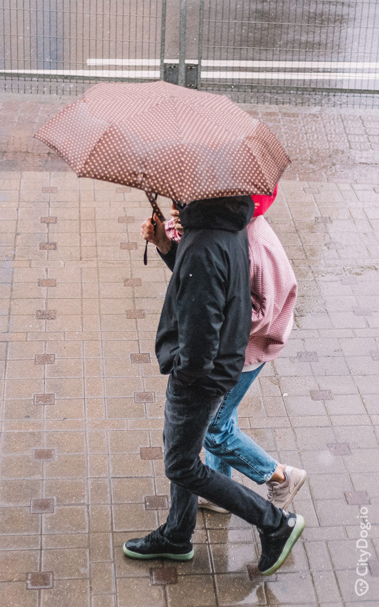 Пара гуляет под дождем на Немиге.