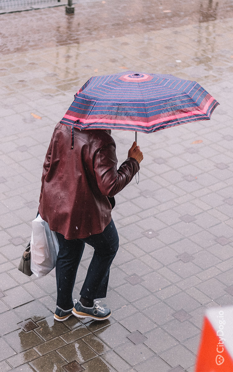 Женщина со сломанным зонтом идет по Немиге.