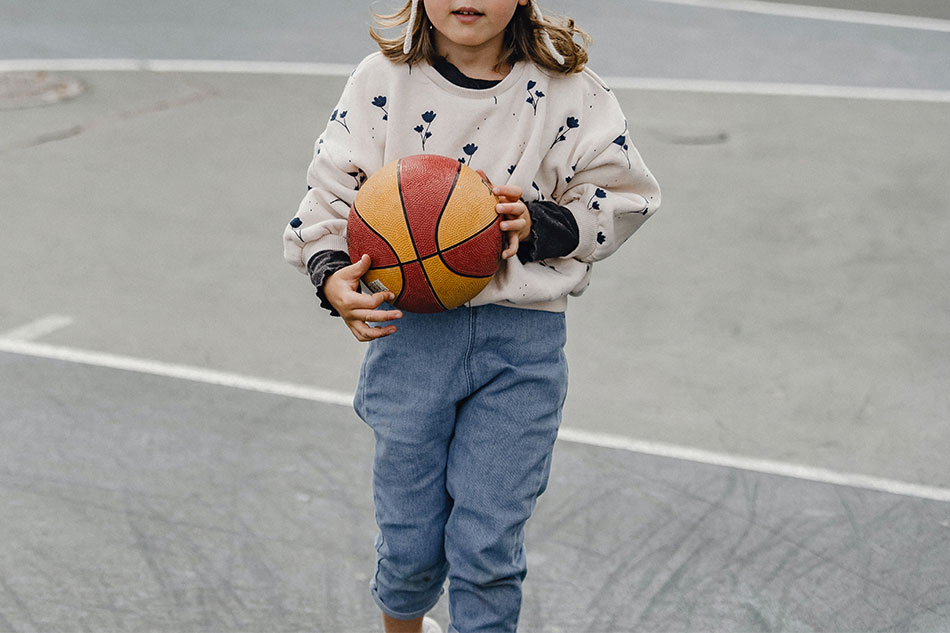 Девочка играет с мячом.