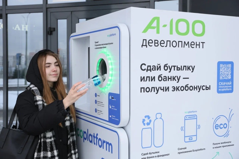 Девушка сдает пластиковую бутылку в автомат. 