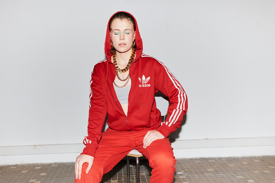 Фотография Ники Юрчук, беларуско-польской исполнительницы, в спортивном костюме Adidas.