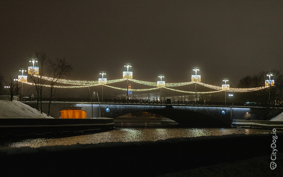 Мост, река, светящиеся гирлянды.