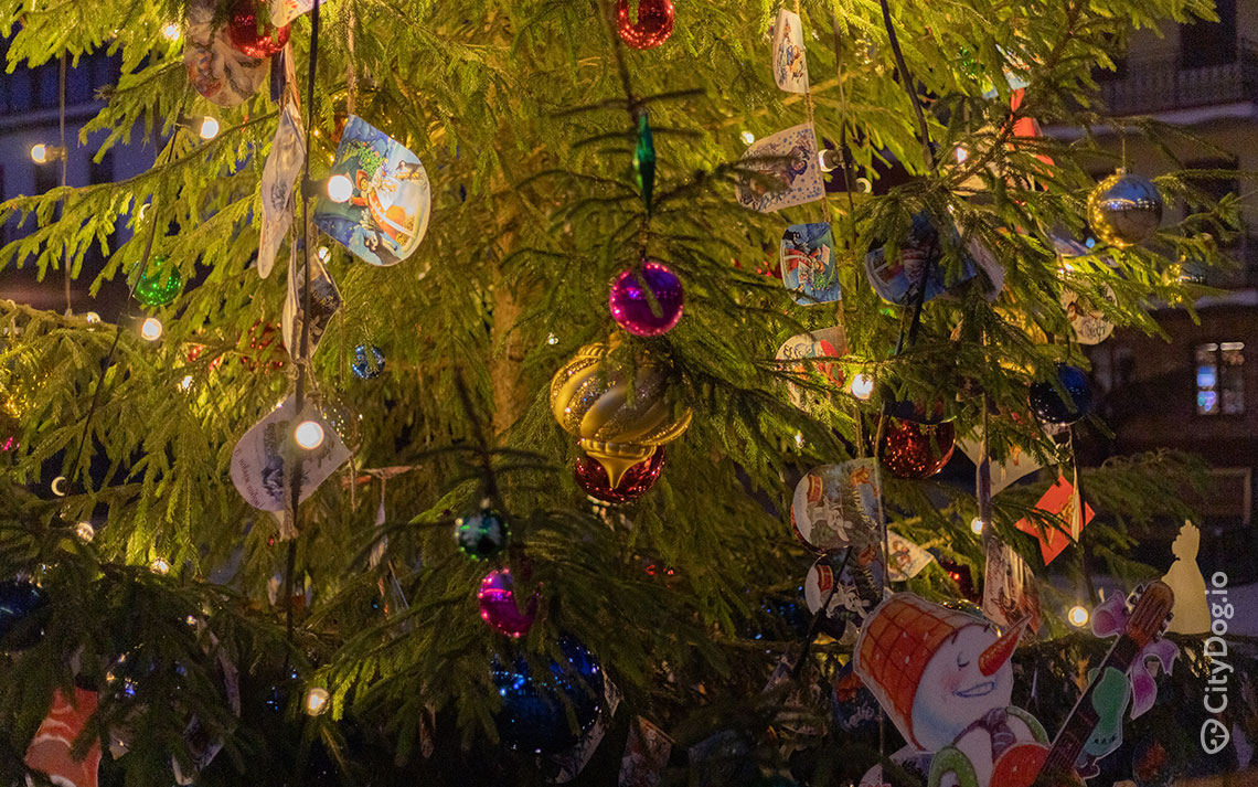 Живая новогодняя елка, украшенная игрушками и фонариками. 
