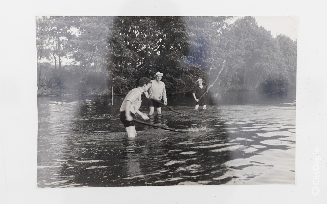 Трое мужчин ловят рыбу в озере.