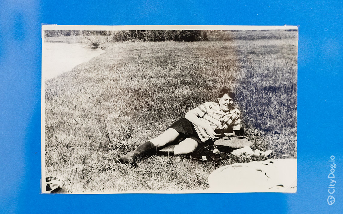 Фотография, на которой мужчина в майке и шортах лежит на траве.