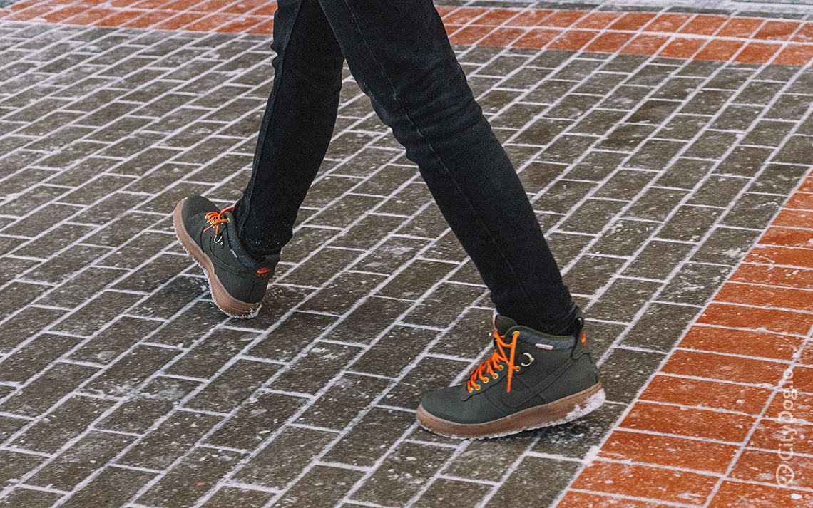 Мужчина в кроссовках с оранжевыми шнурками.