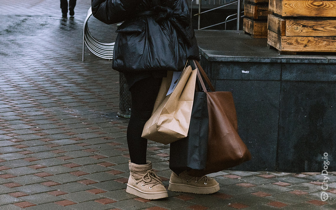 Девушка с коричневым шоппером и пакетами.