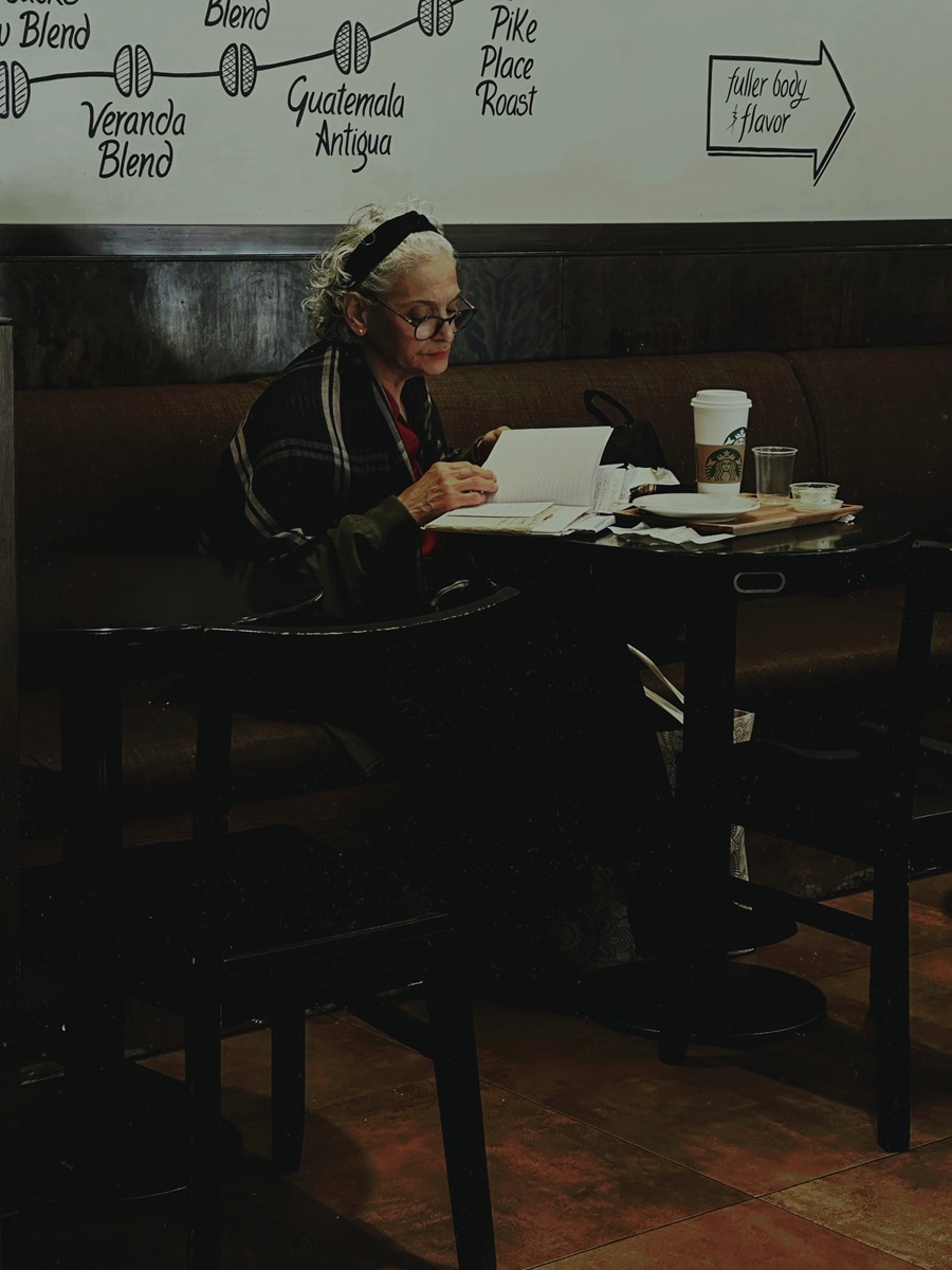 Пожилая женщина читает книгу в Starbucks в Буэнос-Айресе.
