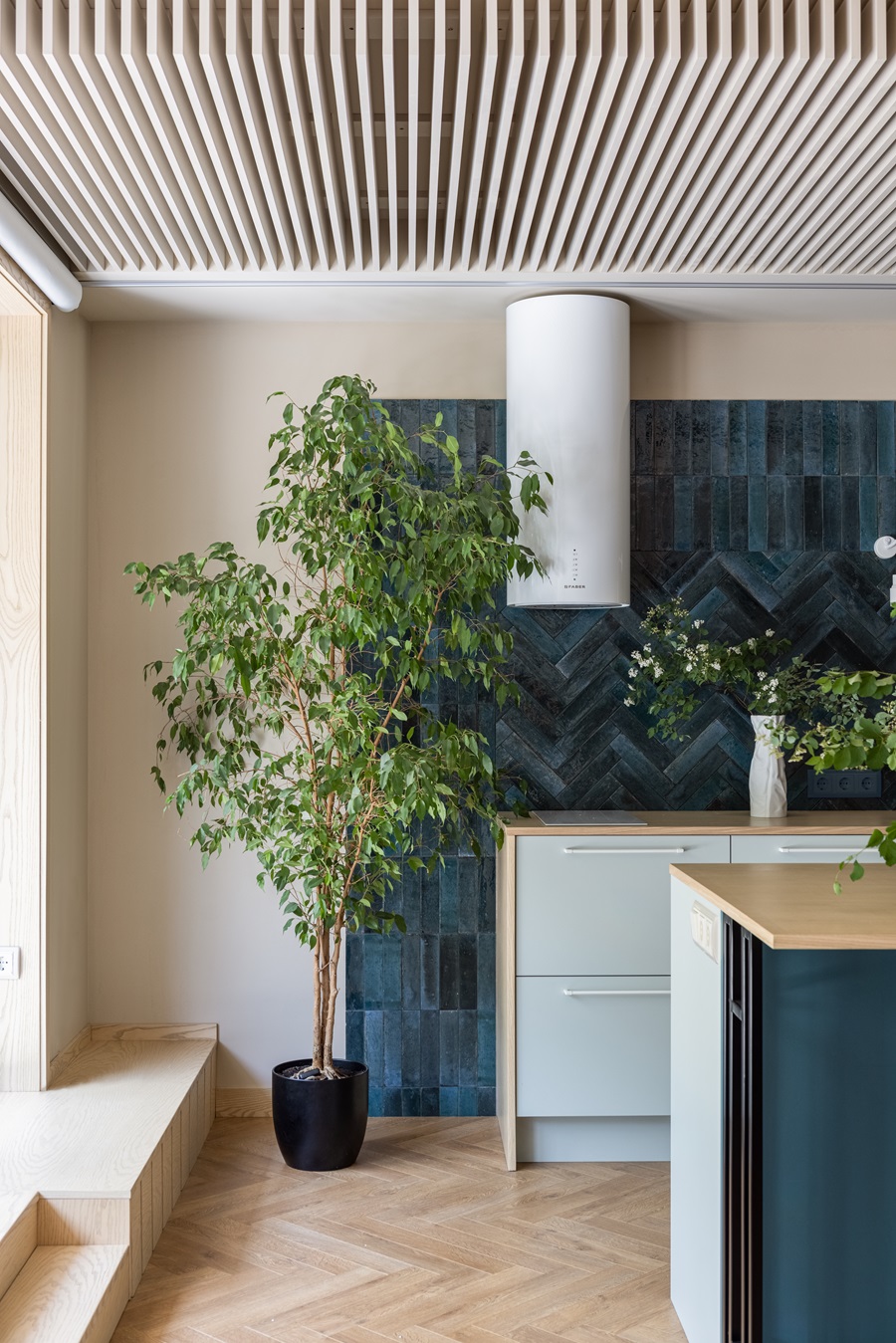 Рейки на потолке и зеленые комнатные растения на кухне. 