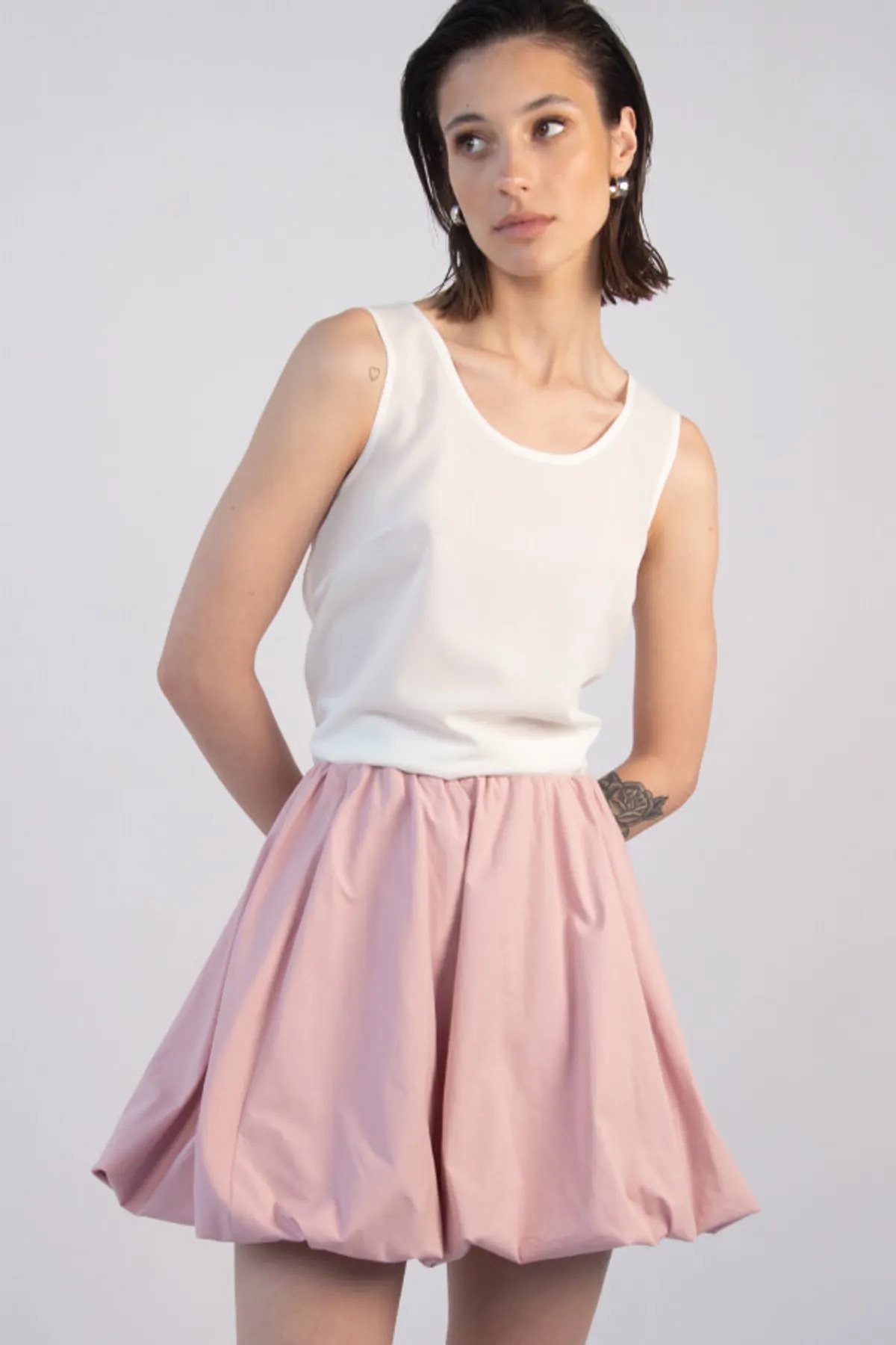 Девушка в короткой розовой юбке-баллоне из хлопка от беларуского бренда Lsd.clothing. 