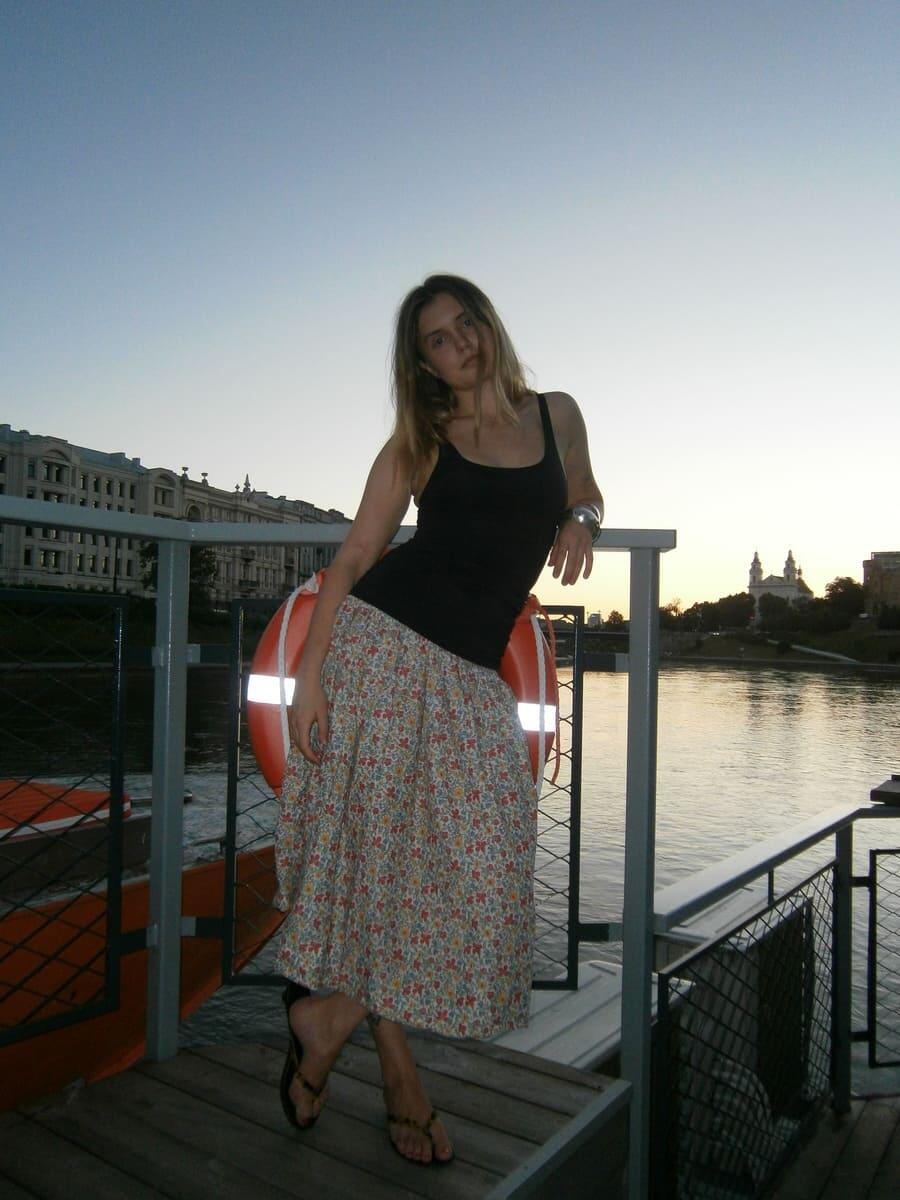 Девушка в черной майке H&M и юбке в мелкий цветок. 